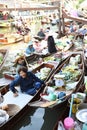 AMPHAWA Ã¢â¬â APRIL 29: Wooden boats are loaded with fruits from the orchards at Tha kha floating market Royalty Free Stock Photo